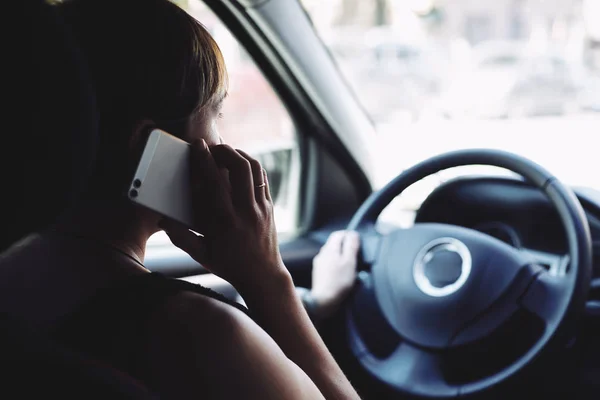 Mujer en el coche hablando por teléfono móvil mientras conduce — Foto de Stock