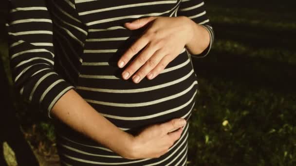 Mujer embarazada en vestido a rayas — Vídeo de stock