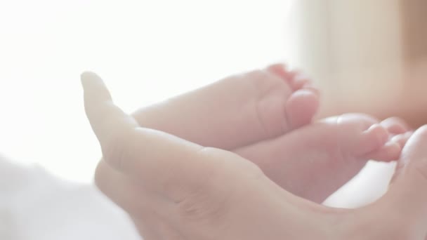 Madre sostenga sus pies de bebé — Vídeo de stock