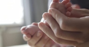 Yeni doğan bebeğinin ayak masajı yapıyor anne