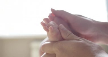 Yeni doğan bebeğinin ayak masajı yapıyor anne