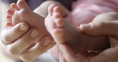 Yeni doğan bebeğinin ayak masajı yapıyor anne