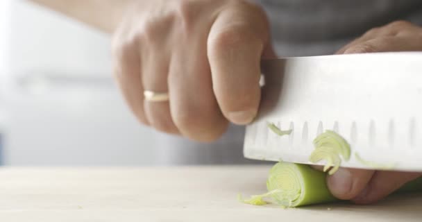 Masak halus memotong daun bawang di papan kayu — Stok Video