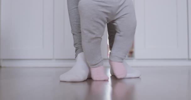 Mother assisting in her baby first steps. — Stock Video