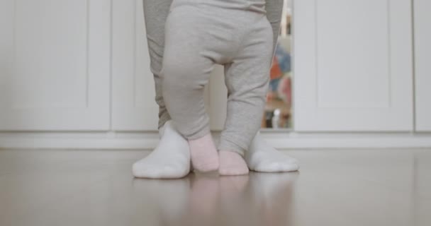 Mother assisting in her baby first steps. — Stock Video
