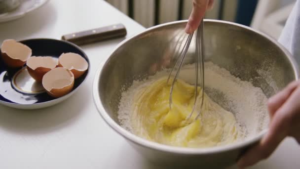 Osoba přípravě domácí omeleta míchání vejce s rukou corolla. — Stock video