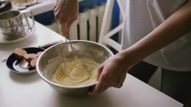 Person preparing homemade omelette mixing eggs with hand corolla. — Stock Video