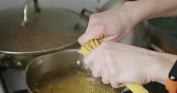 Добавляет спагетти в кастрюлю с кипящей водой — стоковое видео