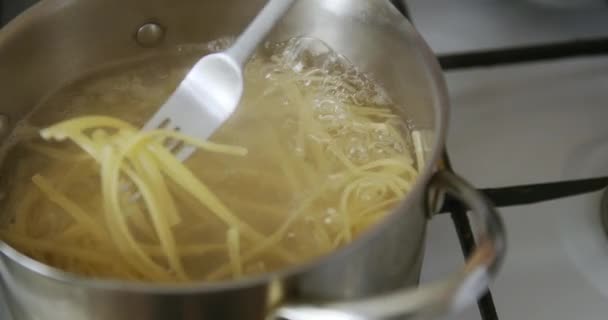 Gli spaghetti vengono cotti in pentola di acqua bollente — Video Stock