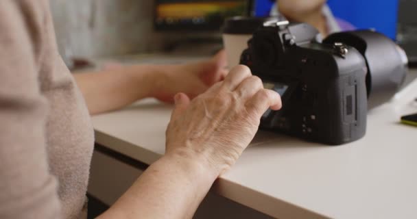 Kobieta fotograf przeglądając zdjęcia na jej kamery w domu — Wideo stockowe