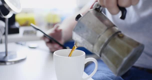 Gröda skott person hälla kaffe i kopp från geyser kaffebryggare. — Stockvideo