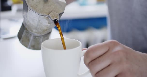 Gröda skott person hälla kaffe i kopp från geyser kaffebryggare. — Stockvideo