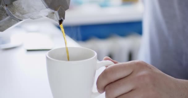 Gröda skott person hälla kaffe i kopp från geyser kaffebryggare. — Stockvideo