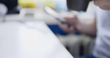 Adam smartphone ile masada oturur ve taze sıcak içecek içecekler