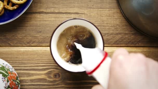 Het gieten van stroom melk van fles aan de kop van Americano — Stockvideo