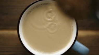 Süt ile kahve fincan içine kaşık kamışı şeker dökün