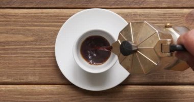 Kahve fincanına gayzer mocha kahve makinesinden dökülüyor.