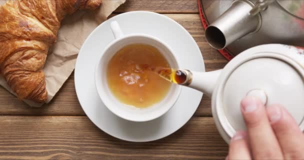 Person gießt heißen frischen schwarzen Tee in einen Becher — Stockvideo