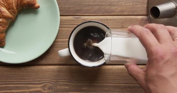 Persona que vierte leche en el café negro de la mañana . — Vídeos de Stock