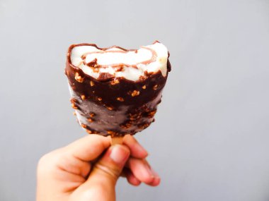 Gri arka planda vanilyalı çikolatalı dondurma.