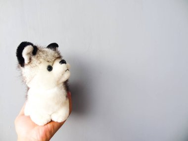 Gri arka planda gümüş köpek şeklinde bir bebek.