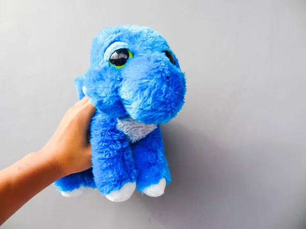 灰色の背景に青い色の恐竜の形をした人形 — ストック写真