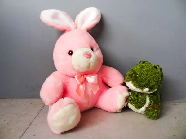 Pembe Tavşan Şeklinde Bir Bebek Gri Arka Planda Arkadaşı — Stok fotoğraf