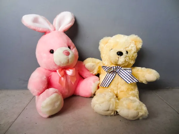 ピンクのウサギの形をした人形と灰色の背景の彼女の友人 — ストック写真