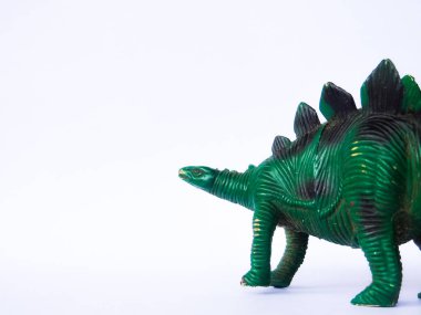 Beyaz arka planda yeşil dinozor oyuncağı