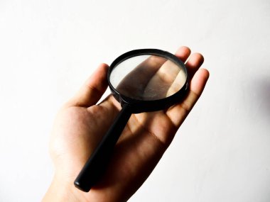 Beyaz arkaplanda elle büyüteç