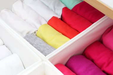 Çocuk odasında giysilerin dikey depolanması. Giysiler sürgüde dikey depolama için katlandı. Bir kızın dolabı..