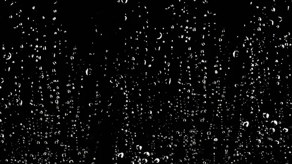 Yağmur mevsimi geldiğinde siyah zemin üzerindeki camların üzerine beyaz yağmur damlası veya su damlası rengi.
