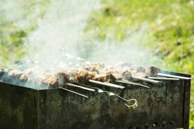 Barbekü ızgara yazları açık havada ellerini bile kavurma için şiş çevirmek.
