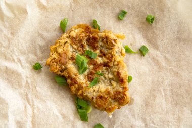 Taze kızarmış domuz eti, yeşil soğan ve ketçap ile serpilir. Ambalaj kağıdı düzenleme