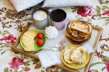 Lezzetli kahvaltı tost ve büyük bir fincan kahve ile yatakta