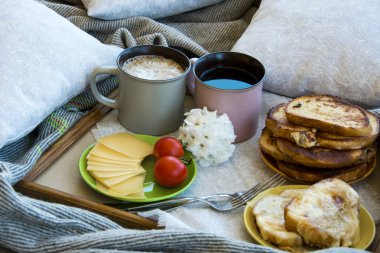 Lezzetli kahvaltı tost ve büyük bir fincan kahve ile yatakta