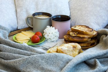 Lezzetli kahvaltı tost ve büyük bir fincan kahve ile yatakta