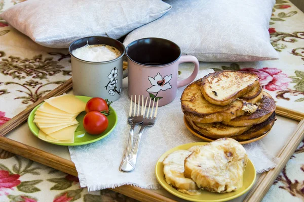 Delicious breakfast in bed with toast and a big cup of coffee