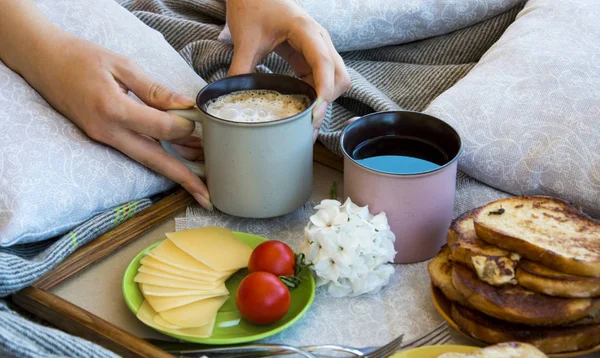 Lezzetli kahvaltı tost ve büyük bir fincan kahve ile yatakta
