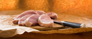 Bir kesme tahtası üzerinde taze Çiğ domuz pirzolası. Ambalaj kağıdı düzenleme