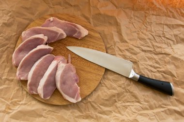 Bir kesme tahtası üzerinde taze Çiğ domuz pirzolası. Ambalaj kağıdı düzenleme