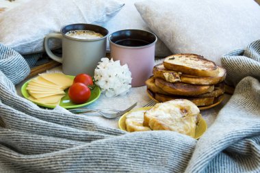 Lezzetli kahvaltı tost ve büyük bir fincan kahve ile yatakta