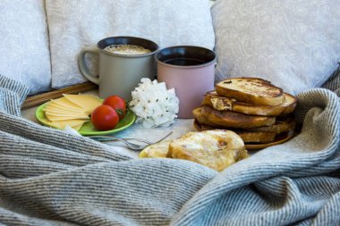 Lezzetli kahvaltı tost ve büyük bir fincan kahve ile yatakta