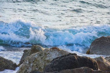 Gün batımından manzara modunda deniz suyu arasında kayalık plaj