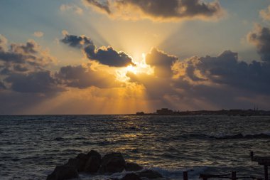 Gün batımından manzara modunda deniz suyu arasında kayalık plaj