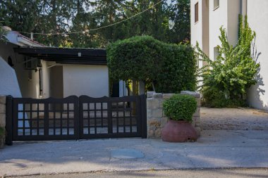 dar sokak, taş beyaz çit, kil sürahi, çiçekli çalılar, Kıbrıs çalılıkları