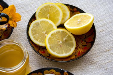 bir daire bir boyalı bardakta çay limon, krep, ekşi krema ve bir tahta kaşık overlaying için dilimlenmiş. rustik tarzı çay partisi