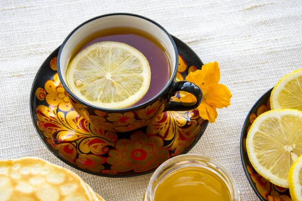 Tee Einer Bemalten Tasse Auf Einer Untertasse Scheiben Geschnittene Zitrone lizenzfreie Stockfotos