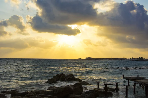 Paysage du coucher du soleil dans l'eau de mer parmi la plage rocheuse — Photo