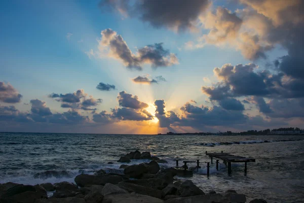 Paysage du coucher du soleil dans l'eau de mer parmi la plage rocheuse — Photo
